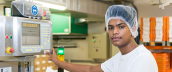 Junger Mann mit Haube in der Produktion Junger Mann mit Haube in der Produktion